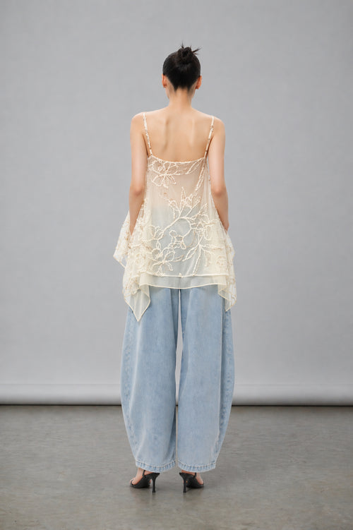 Asian Model wearing a sheer top and light blue pants against a gray background
