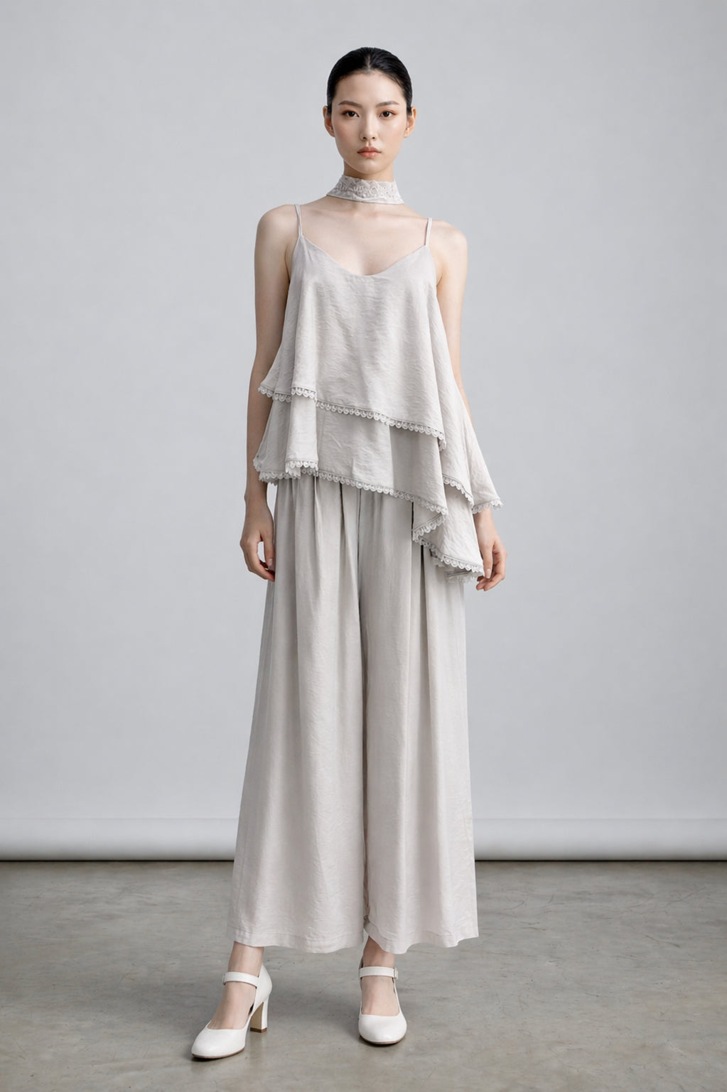 Asian Model wearing a layered outfit in cream, one set, with a plain background
